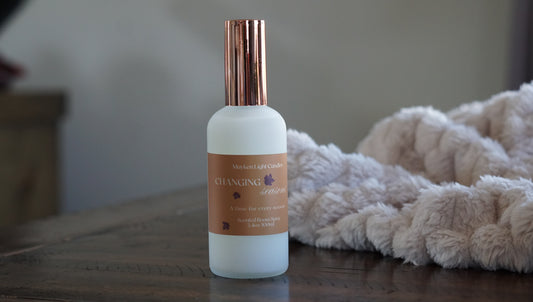 White bottle with rose gold lid. Yellow label with the name Changing Seasons, room spray