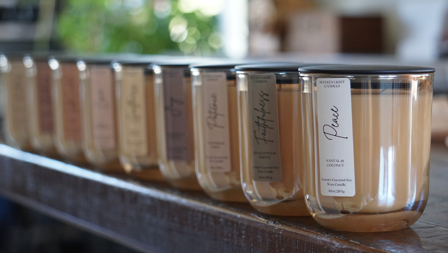 Row of candles with labels on a wooden surface
