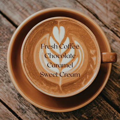 Cappuccino with latte art on a wooden surface, featuring text about coffee flavors.
