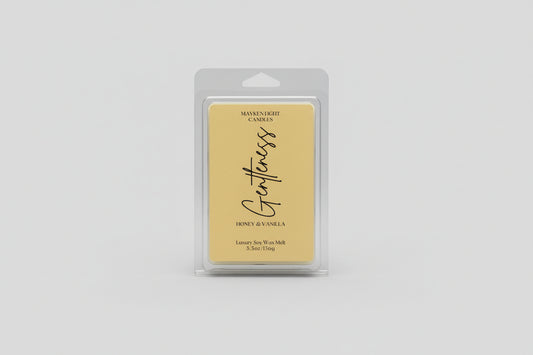 Plastic container with a yellow label reading Mayken Light Candles Gentleness wax melt  scents of honey and vanilla on a white background