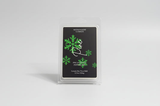Mayken Light Candles wax melt packaging with green snowflake design on a dark surface
