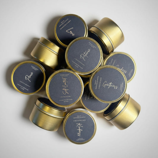Gold tins with black abels on a textured white surface