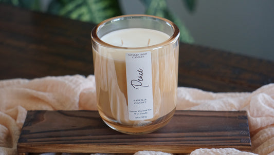 Candle with a label on a wooden coaster on a table