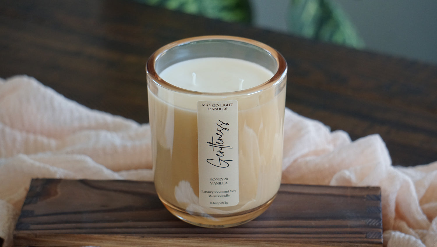 Candle with a label on a wooden surface