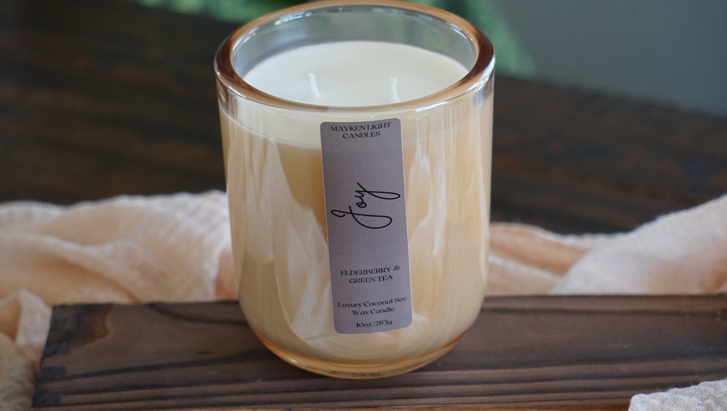 Candle in a glass jar with a label on a wooden surface